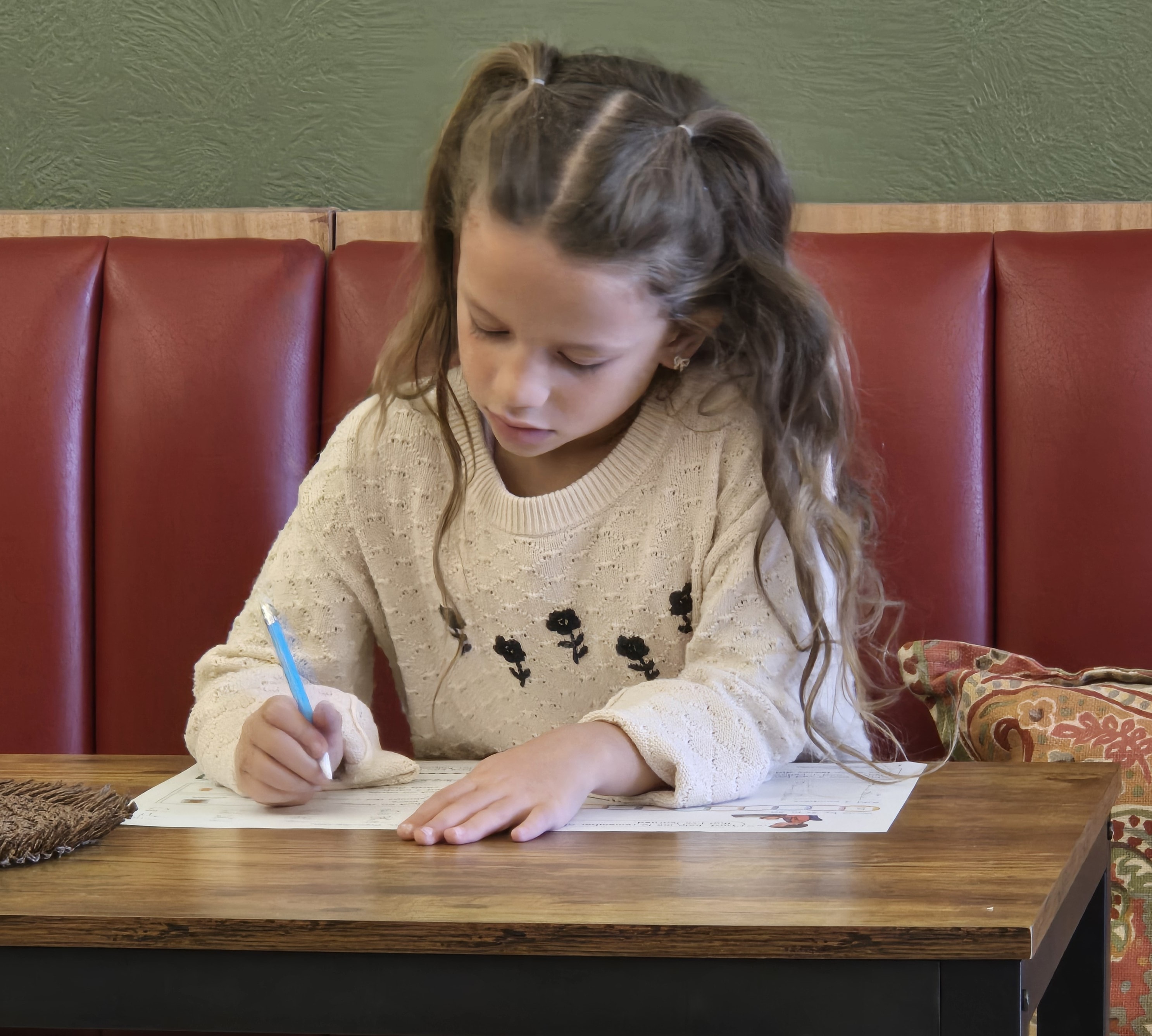 Student writing at a table